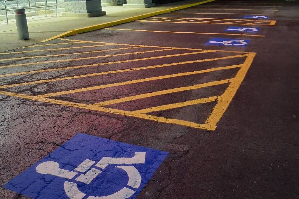 Freshly painted ADA accessible stalls and yellow crosshatch markings striped by Reliable Pro Seal