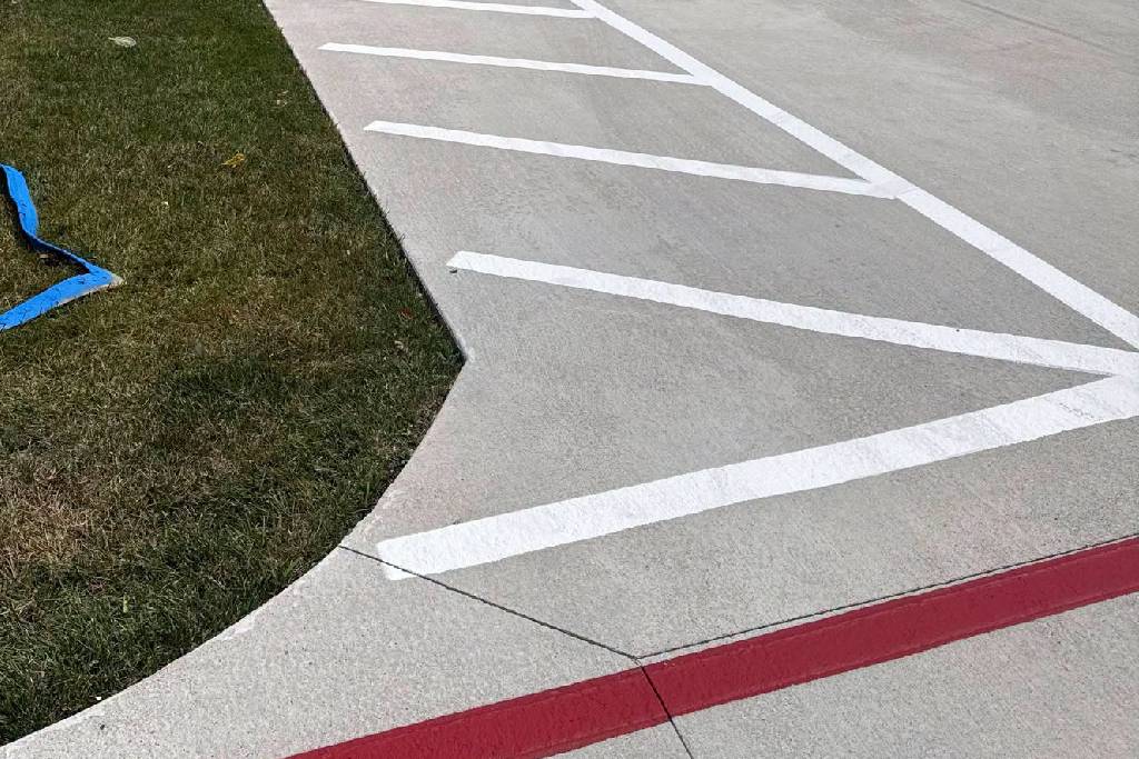 Reliable Pro Seal crew member operating a walk-behind line striper on a freshly sealed lot